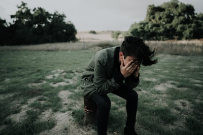 man wearing green jacket sitting on stool chair sadness zoom background