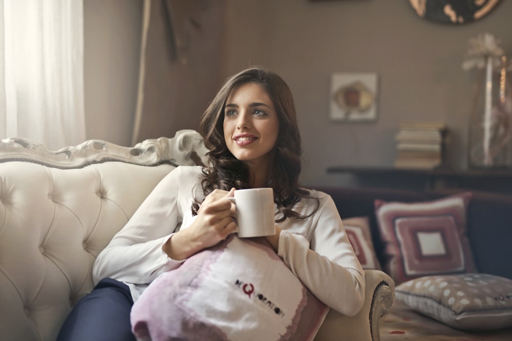 ソファに座るマグカップを持つ女性