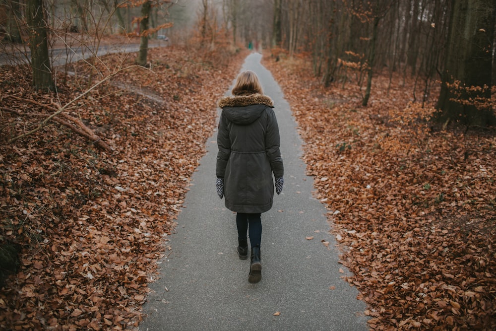 枯れ葉に囲まれた小道を歩く女性たち