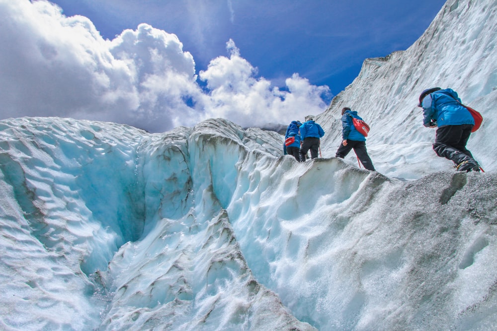 four people climbing mountain at daytime