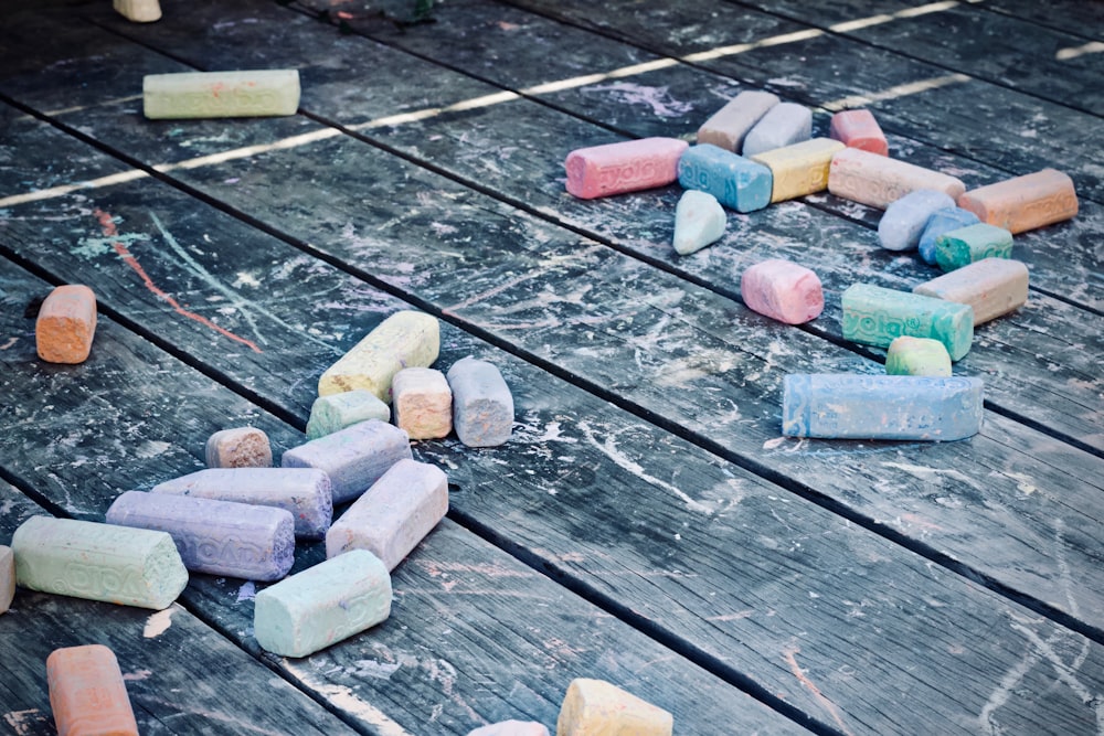 assorted-color color chalks on black wooden surface