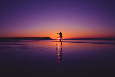 Couple laughing together while watching a sunset performance on a beach.