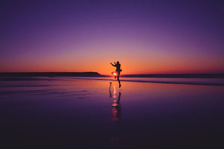 A sun-drenched candid photo of a couple sharing a joyful moment outdoors, framed by soft sand tones and warm terracotta hues.
