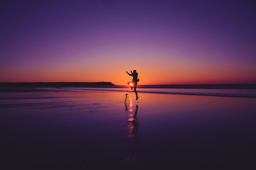 A joyful couple celebrating their engagement on a picturesque beach.