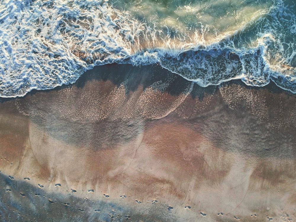 Fotografía aérea de huellas en la costa durante el día