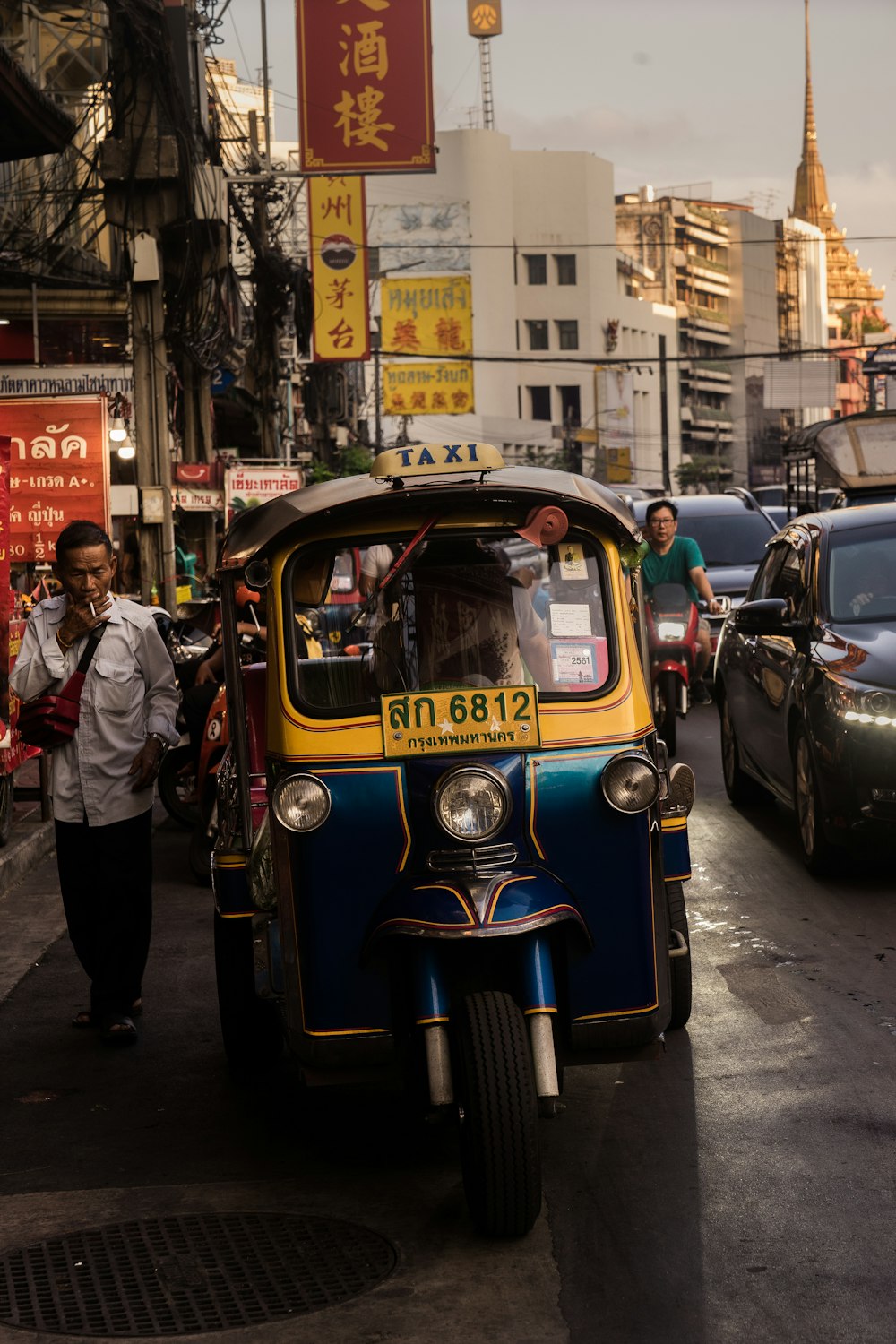 hombre de pie junto a un rickshaw automático amarillo