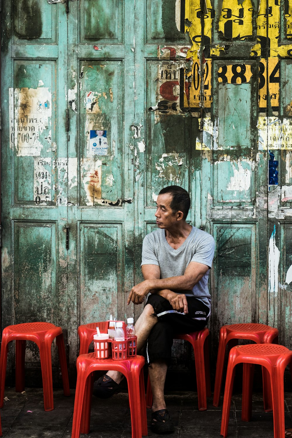 man sitting on red stool