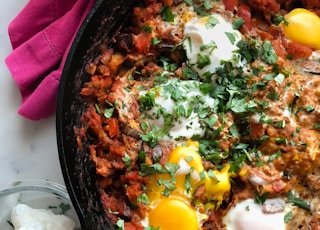 cooked meat with eggs in skillet