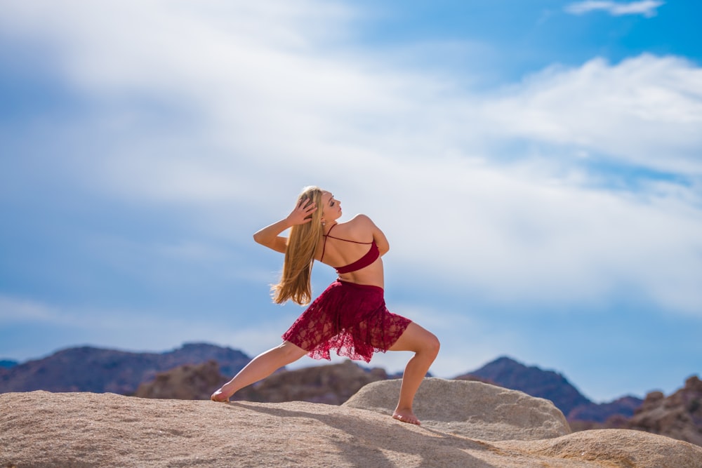 woman dancing near mountain under white clouds during daytime