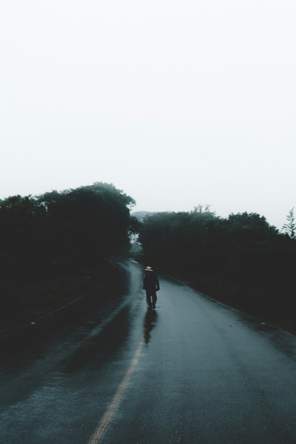 man walking in asphalt road