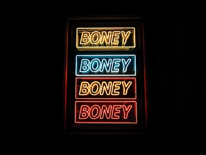photo of yellow, blue, and red Boney neon sign