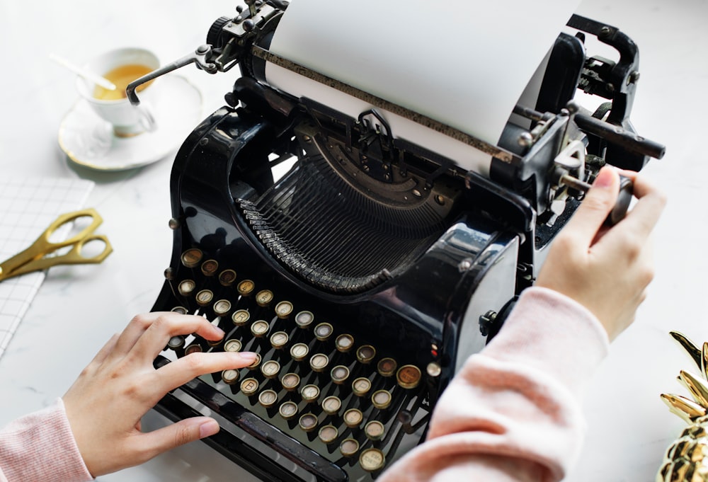 person using black typewriter