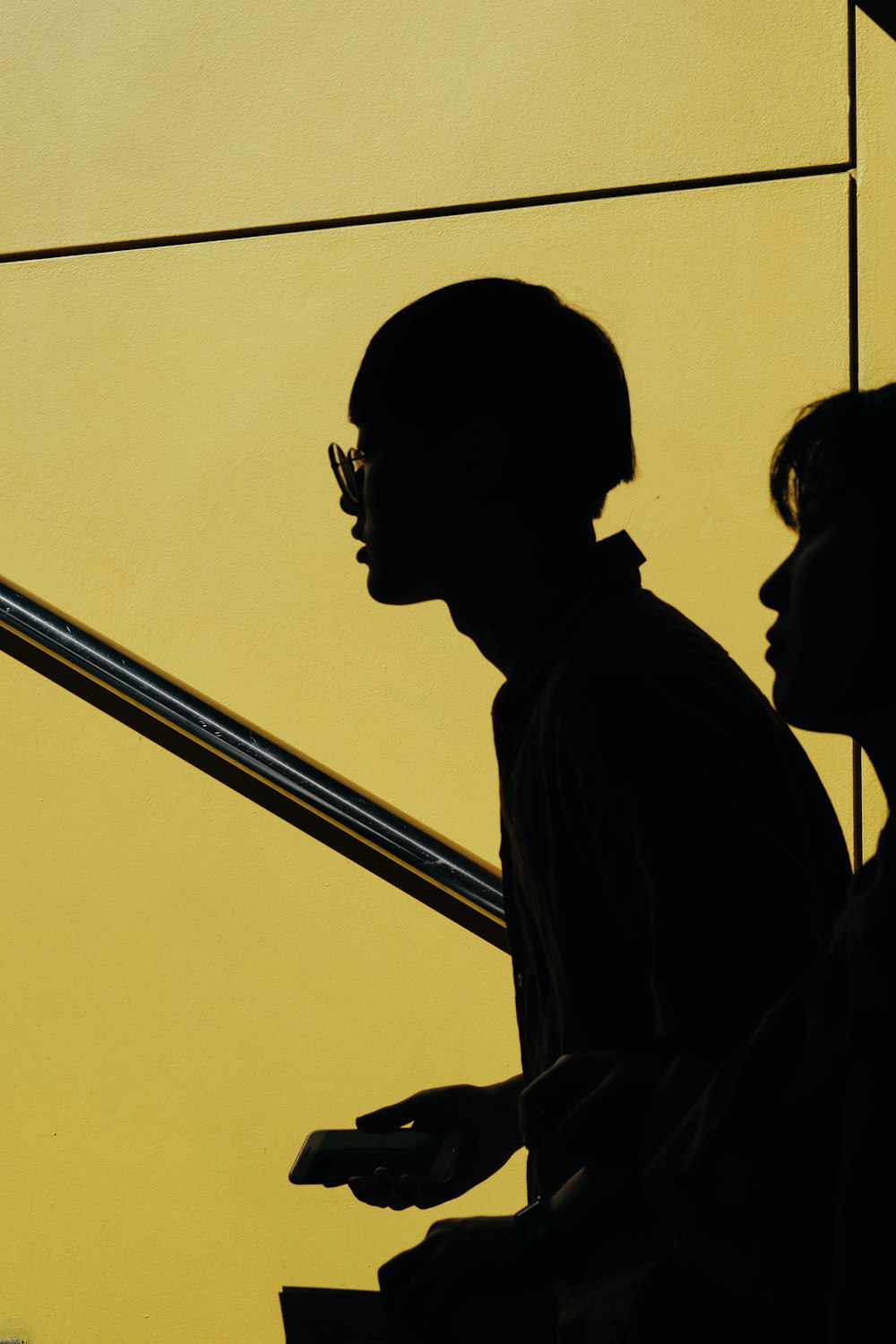 silhouette of two person against yellow background