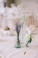 A long-lasting centerpiece with white lilies and delicate baby's breath on a rustic table.