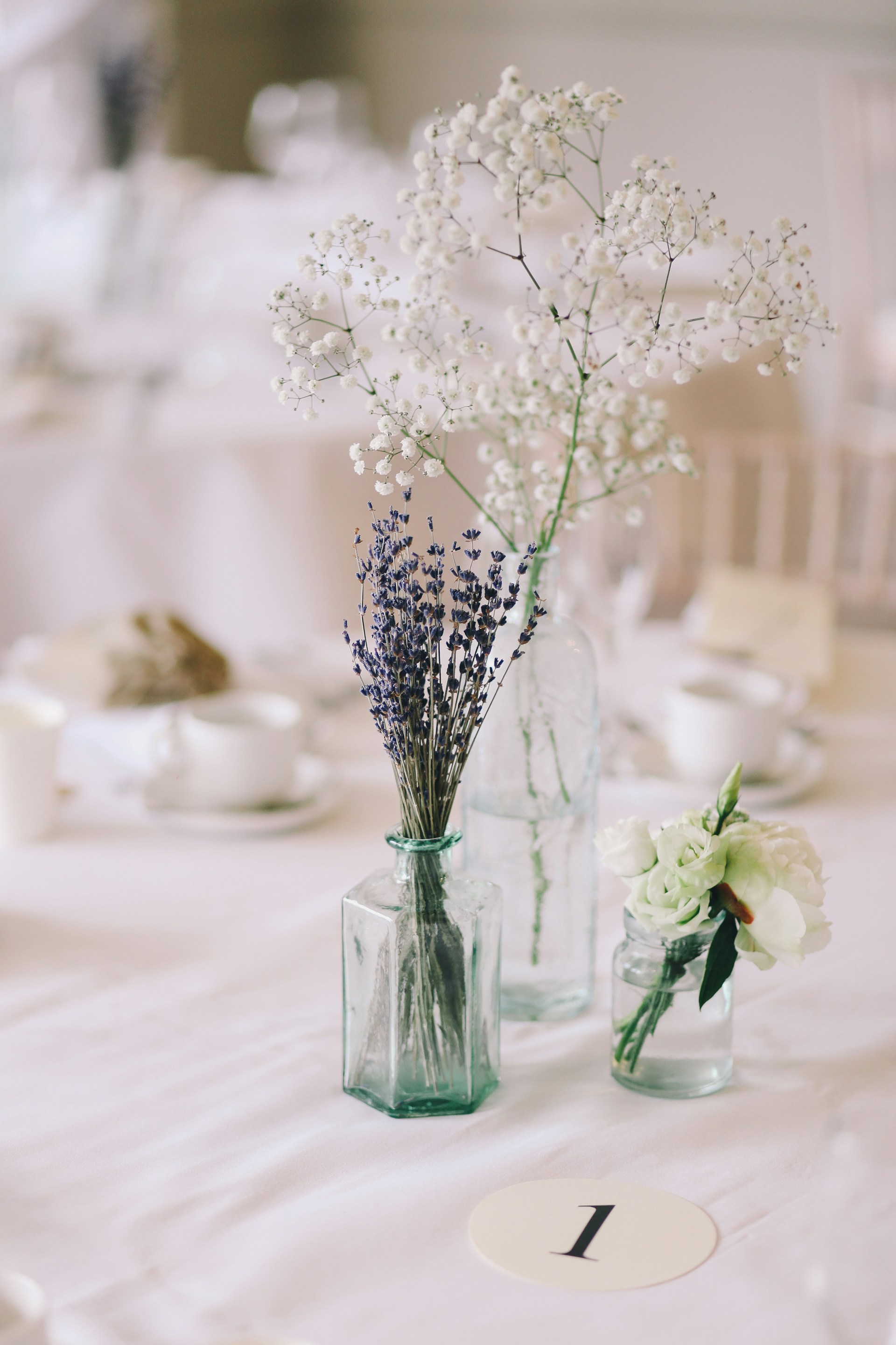 shallow focus photography of flowers in clear glass vases
