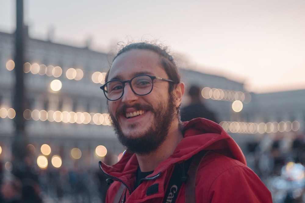 shallow focus photography of man wearing red hoodie