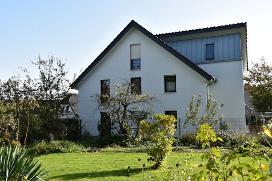 A warm, modern house with a well-maintained garden, bathed in soft natural light.