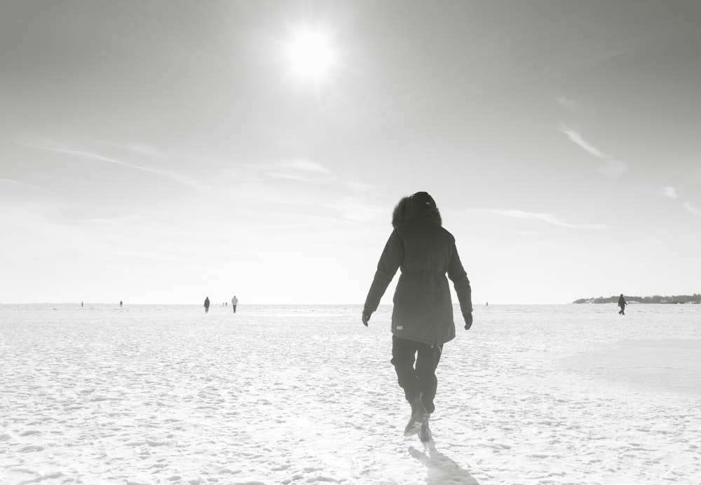 silhouette of woman standing on beach during daytime