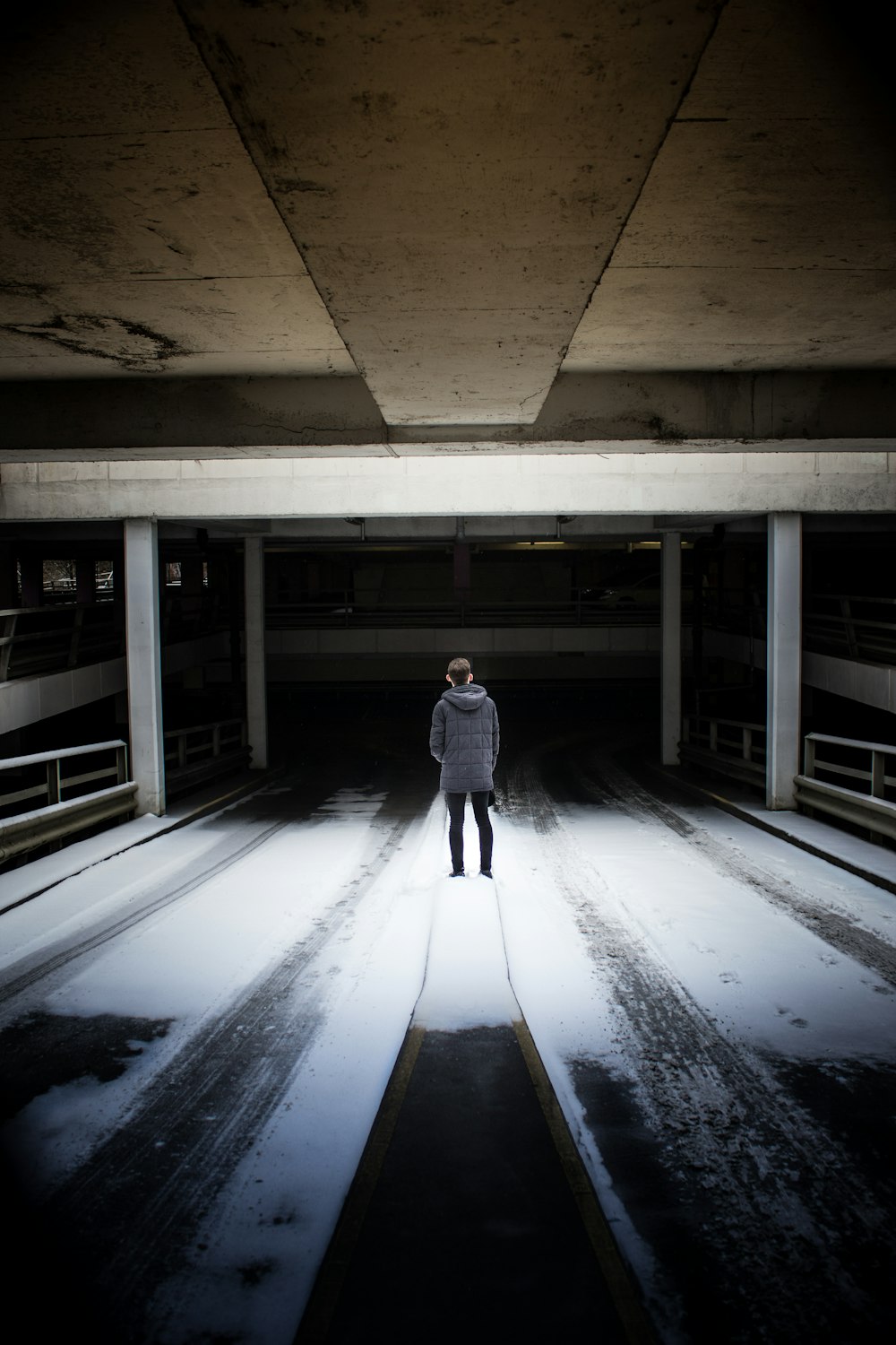 man standing under gray concrete ceiling