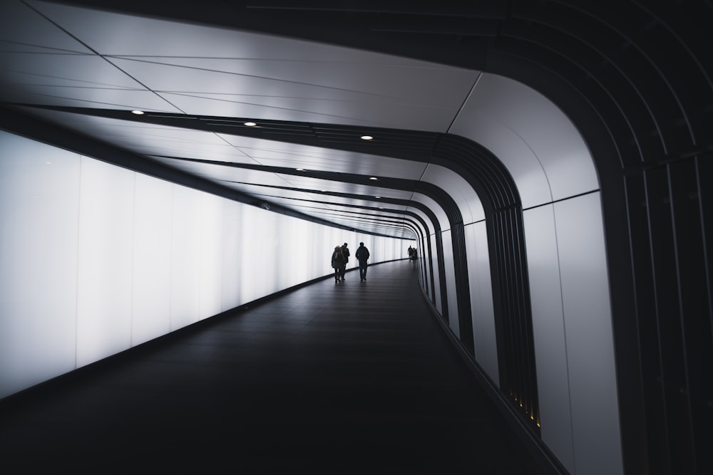 trois personnes marchant sur le couloir