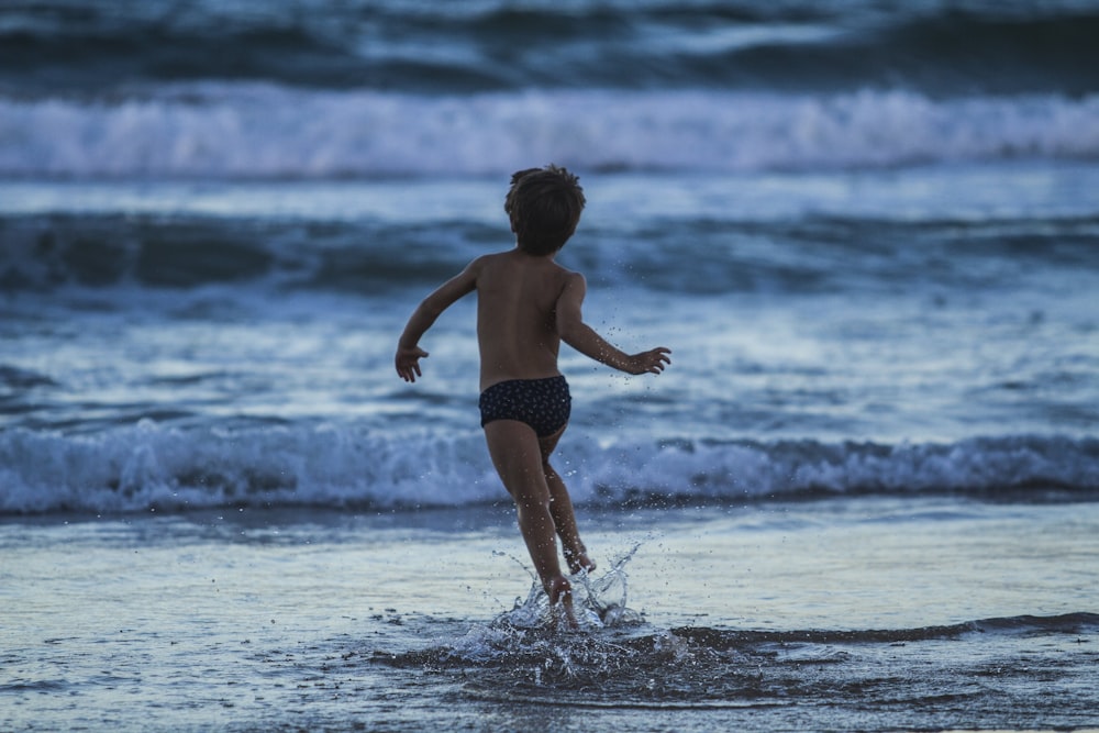 boy running towards seashore