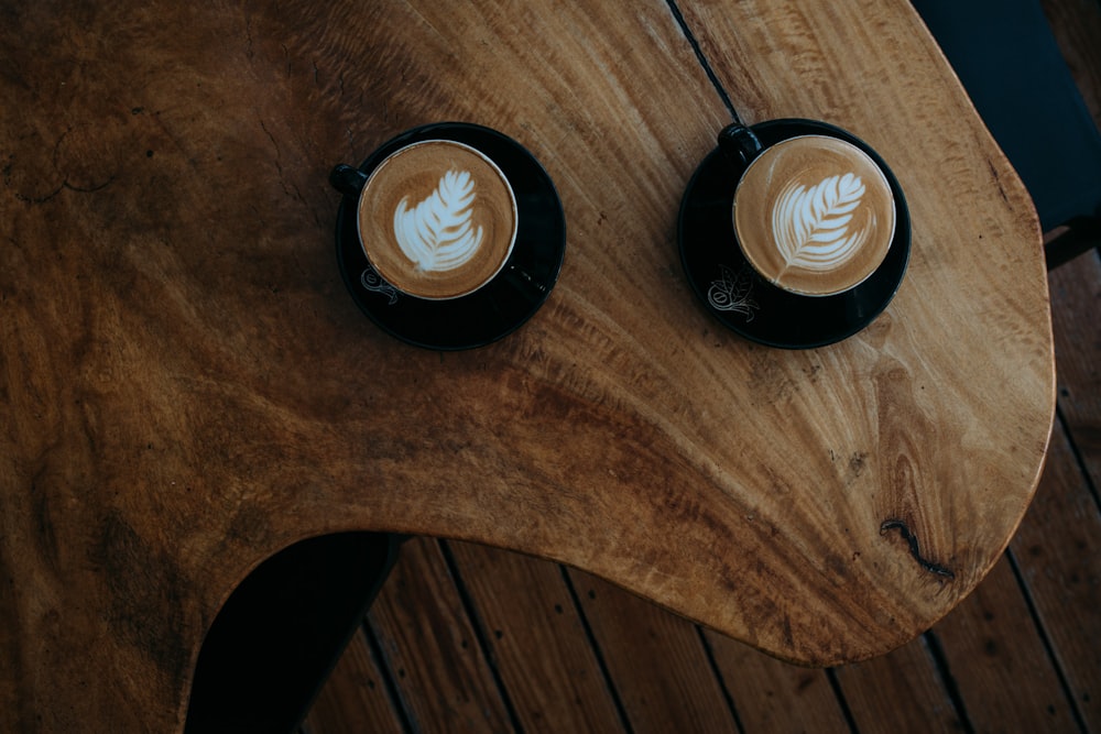 Zwei Kaffeekünste auf braunem Holztisch