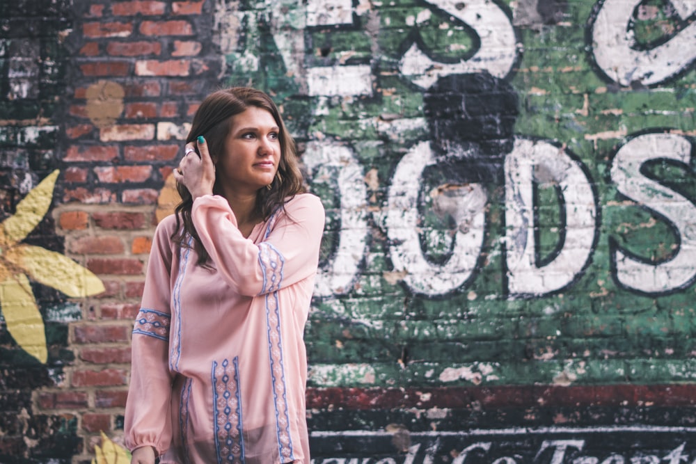 woman standing in front of wall with graffiti art