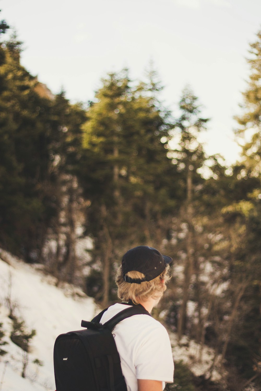 man in white shirt with black backpack