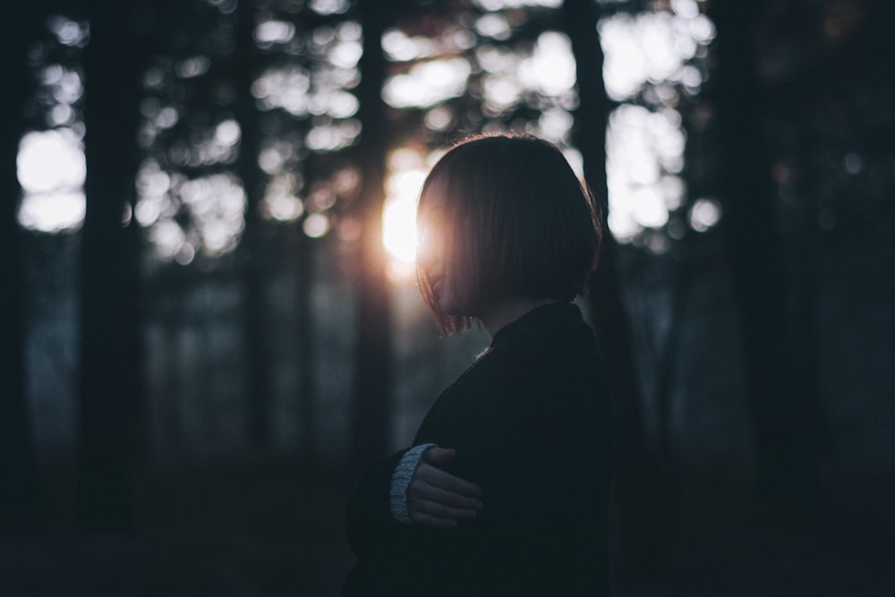 woman in black cardigan near trees