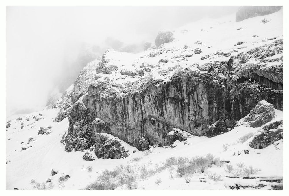 grayscale photography of snow covered cliff