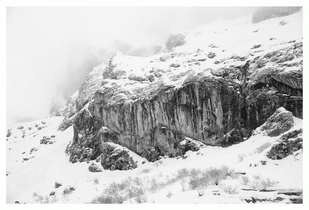 grayscale photography of snow covered cliff