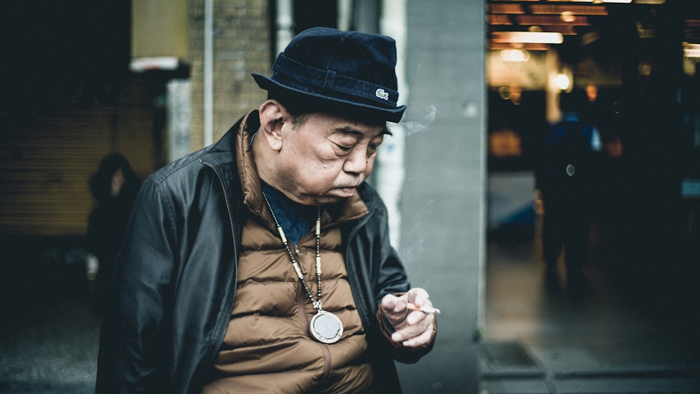 man in black leather jacket using cigarette