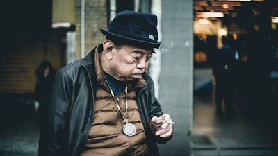 man in black leather jacket using cigarette weary google meet background