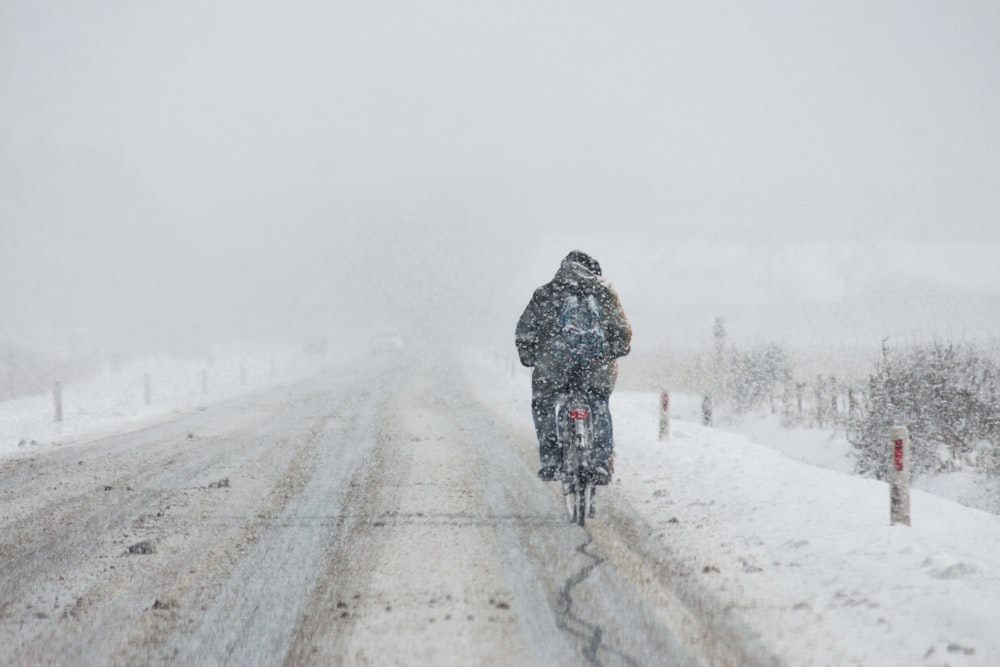 person riding motorcycle on snow coated road