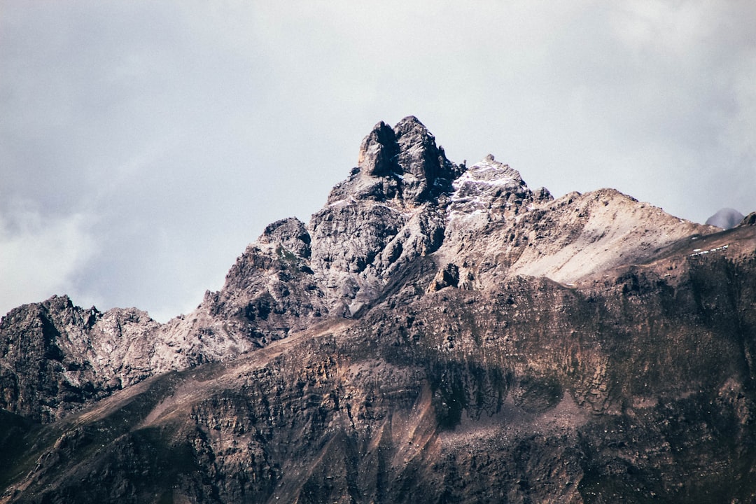 worm's-eye view photography of mountain under cloudy sky