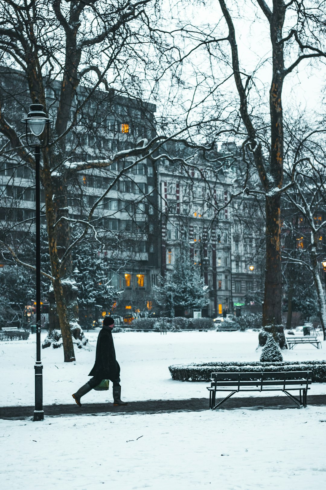 person walking near bench covered on snow