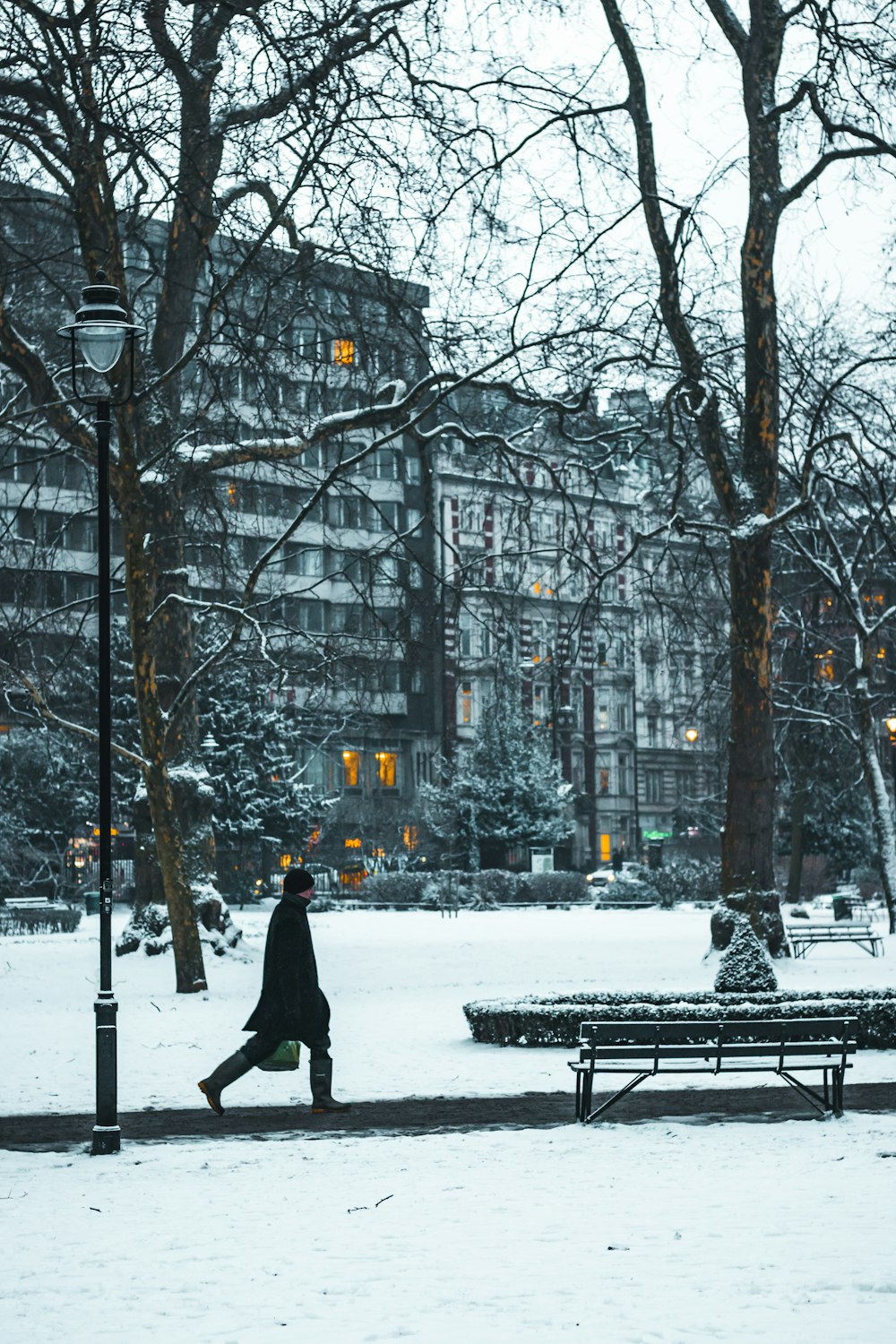 Persona caminando cerca de un banco cubierto de nieve