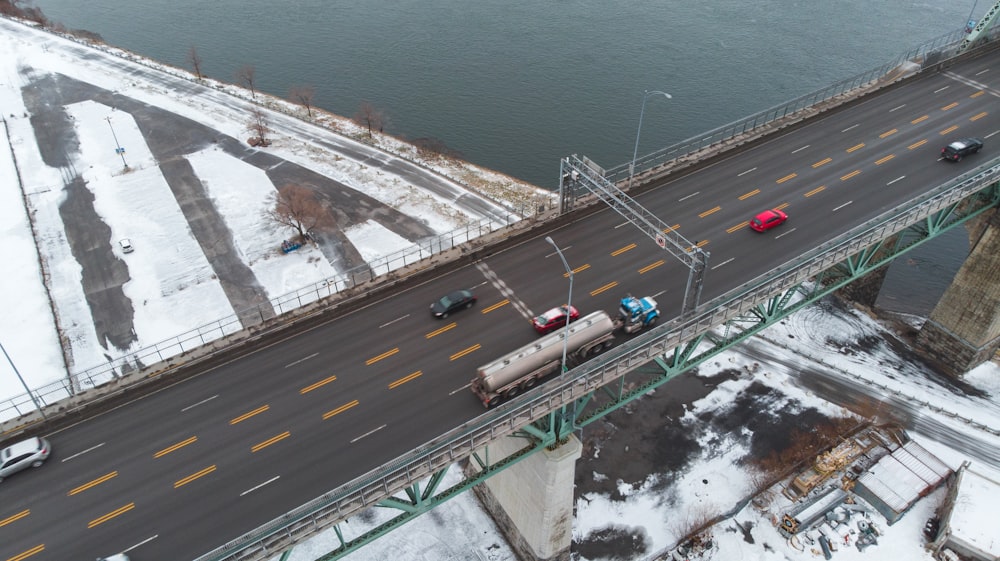 aerial photography of vehicles on steel bridge viewing blue body of water during daytime
