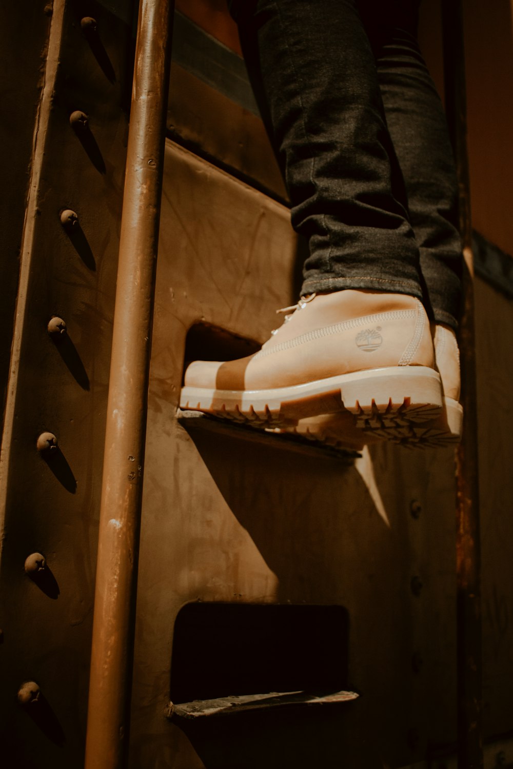 person wearing brown Timberland work boots climbing on stair