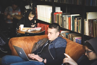 people sitting beside black wooden book case