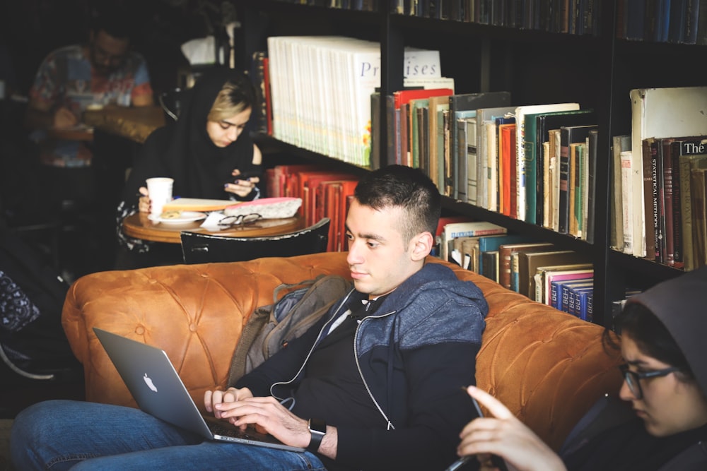 people sitting beside black wooden book case