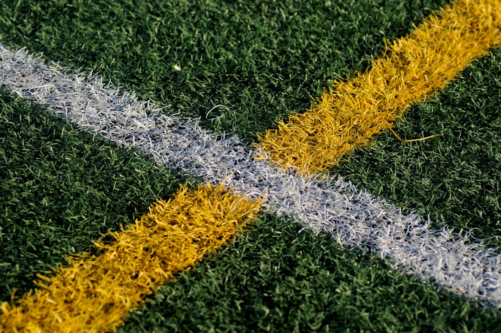 yellow and white line mark on green grasses