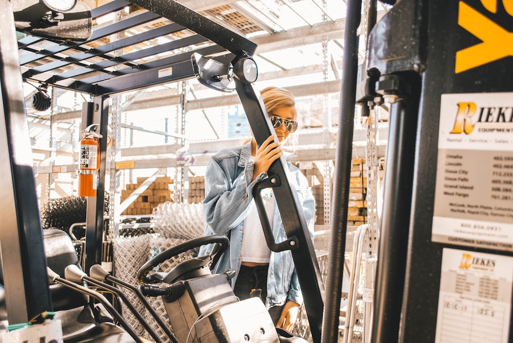 man in blue jacket holding forklift frame