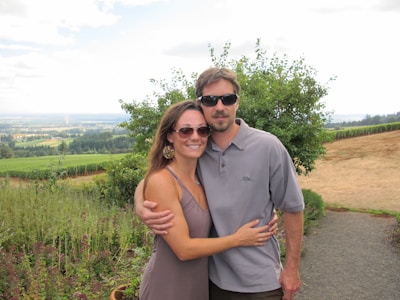 A couple posing happily in a scenic outdoor location.