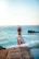 woman standing on cliff raiser her hands