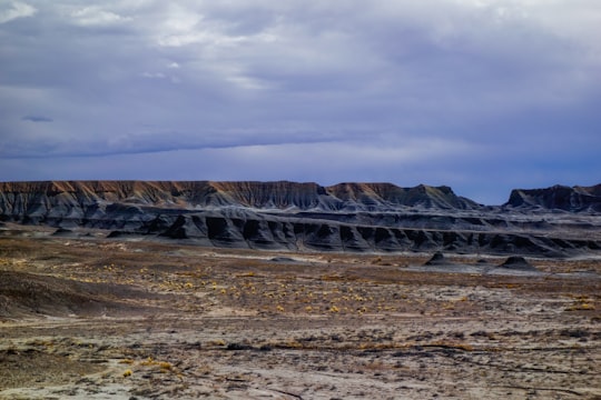 brown and gray mountains under white clouds during daytime in San Rafael Swell United States