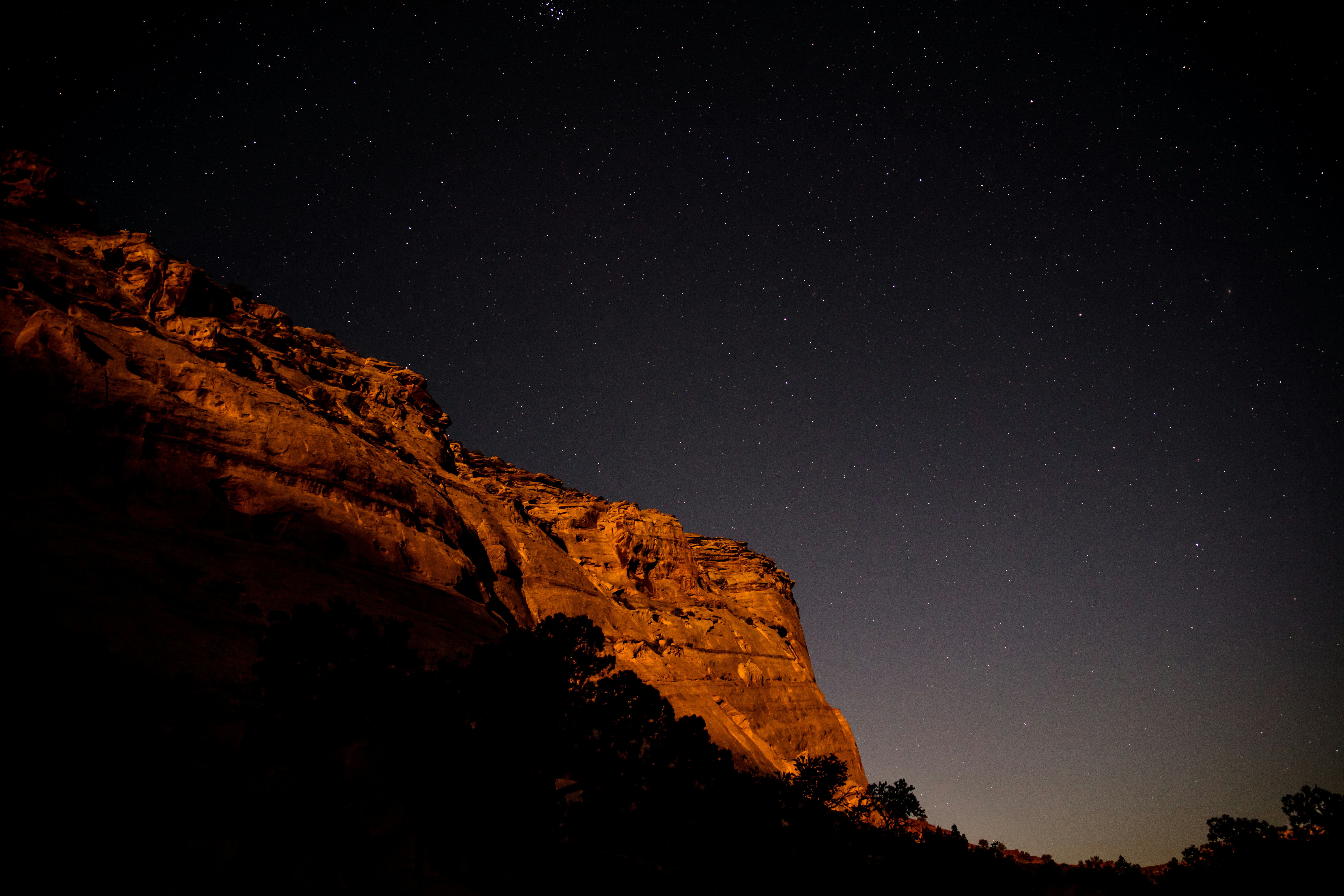 A breathtaking view of the Milky Way galaxy over the dramatic rock formations of Southern Utah at night.