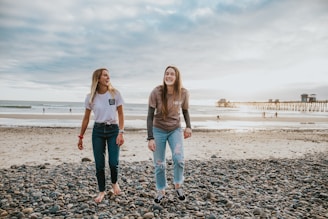 two women walking on pebbles