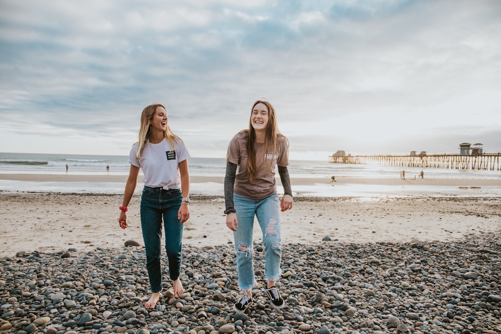 two women walking on pebbles