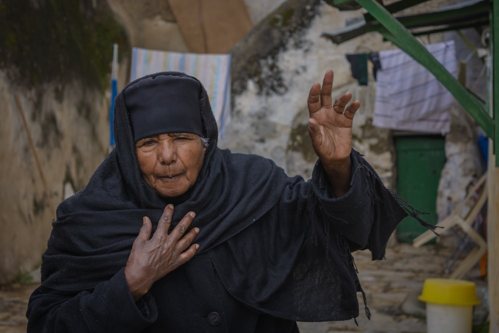 woman raising her left hand outside